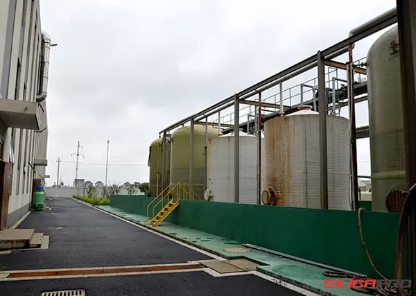 Outdoor stainless steel chemical storage tanks at the high silica fabric plant
