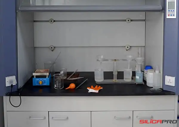 Laboratory fume hood and glassware used for high silica material testing